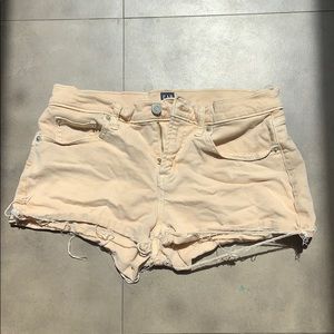 Peach colored jean shorts.
